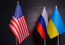 Economic Impact of Russia’s Invasion into Ukraine Flags of the USA, Russia, Ukraine on black background. Relations between Ukraine and Russia, sanctions and the concept of war mediated by the United States.Concept political conflicts between nations.